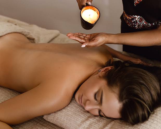 Warm aroma candle oil being poured into the therapist’s hand